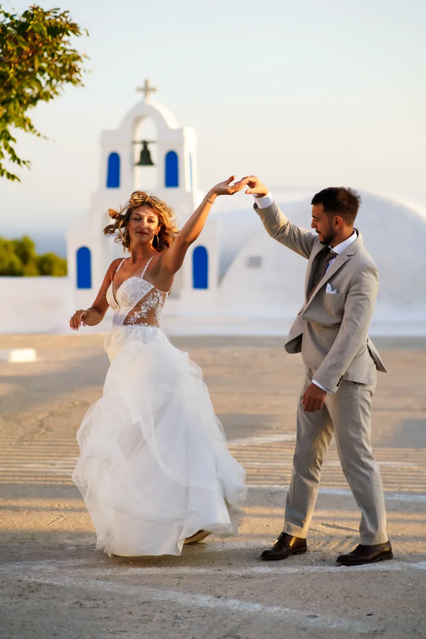 Tańcząca para przed białą kaplicą na Santorini