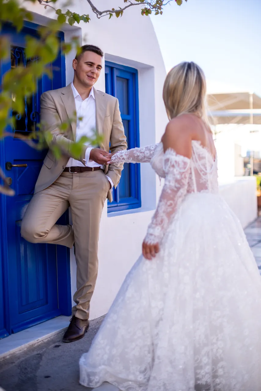 Naturalny portret pary przy niebieskiej stolarce Santorini